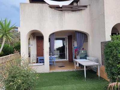 a patio of a house with a table in the yard at Le petit Sampiero 2 in Pietrosella