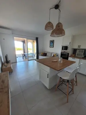 a kitchen with a table and chairs in a room at Le petit Sampiero 2 in Pietrosella