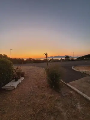 an empty parking lot with a sunset in the background at Le petit Sampiero 2 in Pietrosella