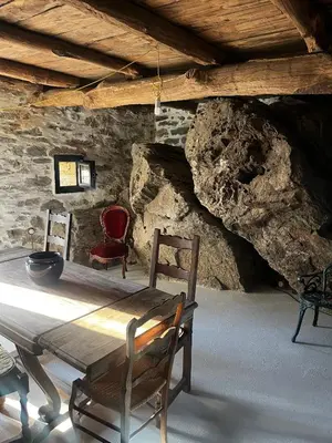 a dining room with a wooden table and two chairs at A Scontra in Moïta