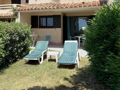 two chairs and a table and chairs in a yard at Mini-villa Bocca del Oro - Sud Porto-Vecchio in Bocca del Oro