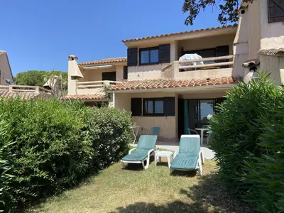 two chairs and a table in front of a house at Mini-villa Bocca del Oro - Sud Porto-Vecchio in Bocca del Oro