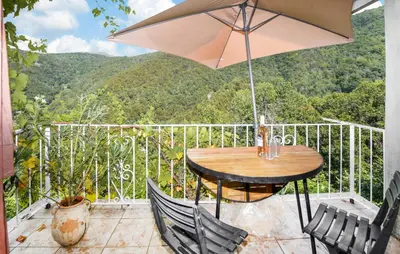 a patio with a table and chairs and an umbrella at Nice Apartment In Sant Andrea Di Bozio in Sant Andrea di Bozio