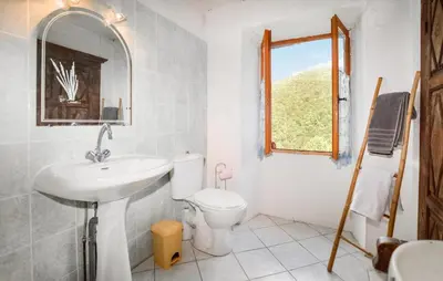 a bathroom with a sink and a toilet and a window at Nice Apartment In Sant Andrea Di Bozio in Sant Andrea di Bozio
