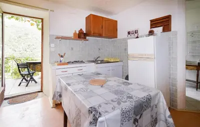 a kitchen with a table and a white refrigerator at Nice Apartment In Sant Andrea Di Bozio in Sant Andrea di Bozio