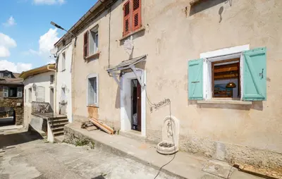 an old building with blue shutters and a window at Nice Apartment In Sant Andrea Di Bozio in Sant Andrea di Bozio