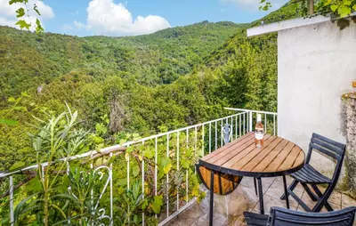 a wooden table and chairs on a balcony with mountains at Nice Apartment In Sant Andrea Di Bozio in Sant Andrea di Bozio