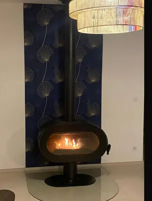 a fireplace in a room with a blue wall at Grande maison à Belgodère Balagne in Belgodère
