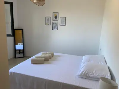 a white bed with four pillows on top of it at Grande maison à Belgodère Balagne in Belgodère