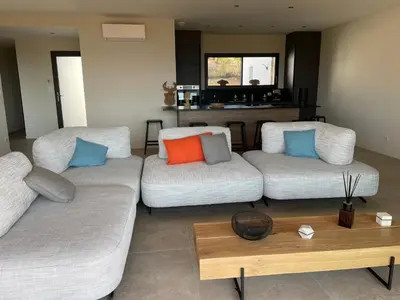 a living room with two couches and a table at Villa vue mer piscine in Pietrosella