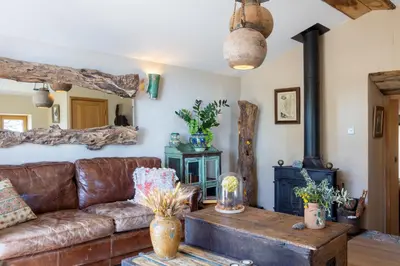 a living room with a couch and a wood stove at Magnifique Bergerie AMORE vue panoramique mer et montagne in Cargèse