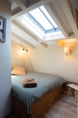 a bed in a room with a skylight at Magnifique Bergerie AMORE vue panoramique mer et montagne in Cargèse