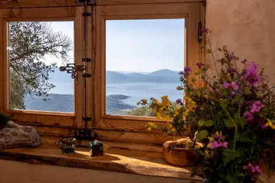 a window with a view of the ocean and mountains at Magnifique Bergerie AMORE vue panoramique mer et montagne in Cargèse