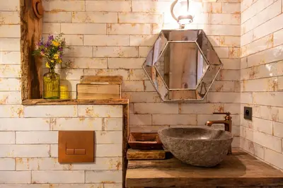 a bathroom with a stone sink and a mirror at Magnifique Bergerie AMORE vue panoramique mer et montagne in Cargèse