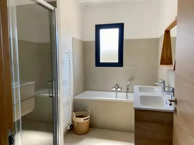 a bathroom with a tub and a sink and a shower at Casa Serena Plage de Lozari 5 kilomètres Ile Rousse 12 kilomètres in Occhiatana