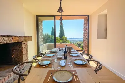 a long wooden table with chairs and a view of the eiffel tower at Villa A Muvra Di Pinarellu in Pinarellu