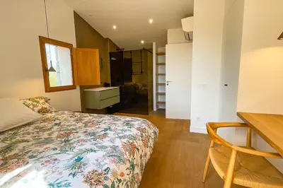 a bedroom with a bed and a desk and a kitchen at Villa A Muvra Di Pinarellu in Pinarellu
