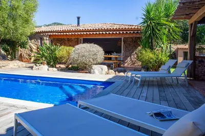 a swimming pool with blue chairs and a house at Casa Isabella Di Santa Lucia in Sainte-Lucie de Porto-Vecchio