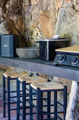a counter with two bar stools and a microwave at Casa Isabella Di Santa Lucia in Sainte-Lucie de Porto-Vecchio