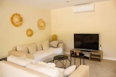 a living room with a couch and a flat screen tv at Casa Isabella Di Santa Lucia in Sainte-Lucie de Porto-Vecchio