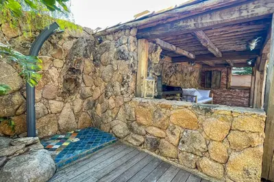 a stone wall next to a building with a table at Casa Isabella Di Santa Lucia in Sainte-Lucie de Porto-Vecchio