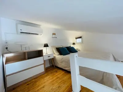 a bedroom with a white bed and a dresser with a drawer at Mini villa agosta plage in Albitreccia