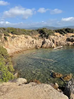 a body of water next to a rocky shore at Mini villa agosta plage in Albitreccia