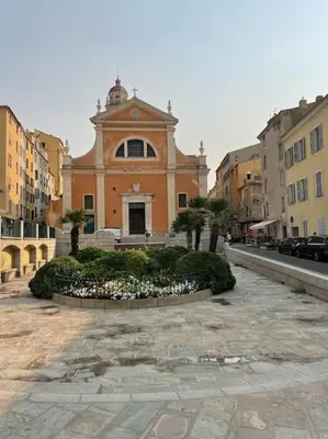 a building with a clock tower in a city at Mini villa agosta plage in Albitreccia