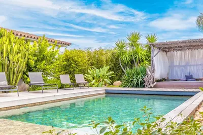 a swimming pool in a backyard with two chairs and a house at Villa Mara in Lecci