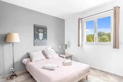 a white bedroom with a bed and a window at Villa Mara in Lecci