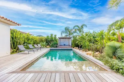 a swimming pool in a backyard with a wooden deck at Villa Mara in Lecci