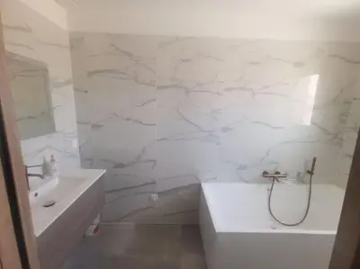 a white bathroom with a tub and a sink and a bath tub at Villa t4 in Lucciana