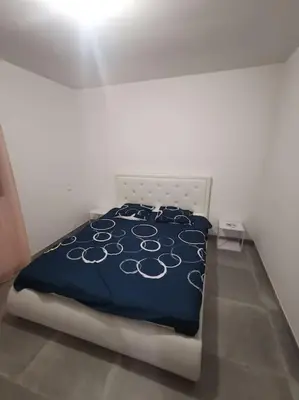 a bedroom with a bed with a blue and white comforter at Villa t4 in Lucciana