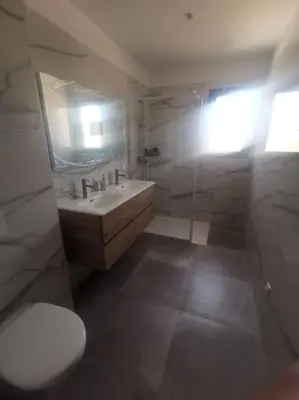 a bathroom with a sink and a toilet and a mirror at Villa t4 in Lucciana