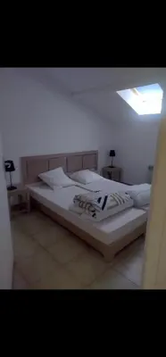 a bedroom with a large bed with white sheets at Appartement Corse in Santa-Maria-Poggio