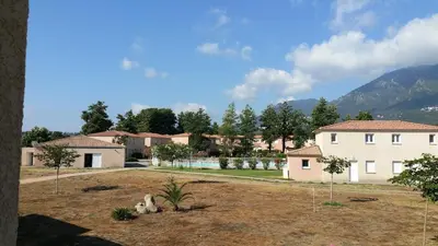 a view of a house with a yard at Appartement Corse in Santa-Maria-Poggio