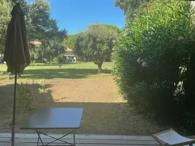 a table and an umbrella in a park at Corse du sud Fiori di cala rossa T2 rez de jardin dans résidence piscine in Lecci