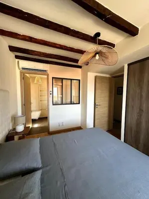 a bedroom with a blue bed and a ceiling fan at Charming air-conditioned house with garden & view in Olmeto