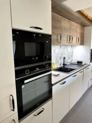 a kitchen with a black oven and a sink at Charming air-conditioned house with garden & view in Olmeto