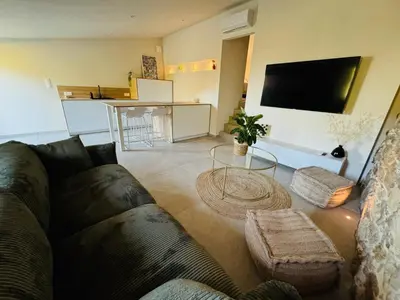 a living room with a couch and a table at Charmante maison en pierre vue mer et piscine privée in Cuttoli-Corticchiato