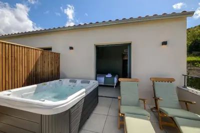 a hot tub on the balcony of a house at Le Belvedere in Lavatoggio