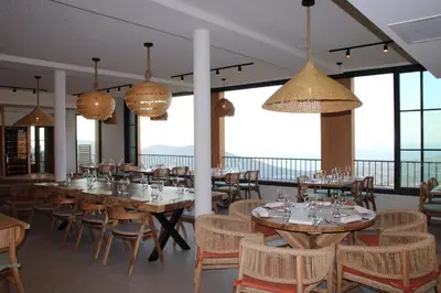 a dining room with tables and chairs and windows at Le Belvedere in Lavatoggio