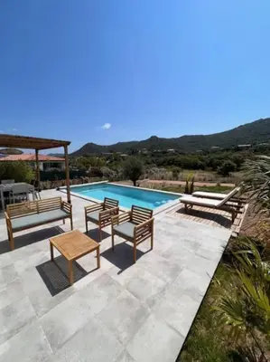 a swimming pool with two benches and a table and a table at Casa Corsu Villa avec piscine in Figari