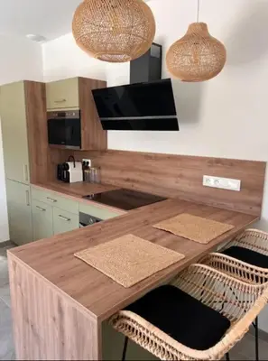 a kitchen with a wooden table and two chairs at Casa Corsu Villa avec piscine in Figari