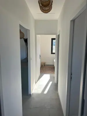 a hallway of a home with white walls and a ceiling at Casa Corsu Villa avec piscine in Figari