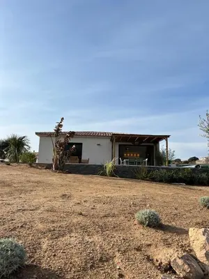 a white house with a porch and a yard at Casa Corsu Villa avec piscine in Figari