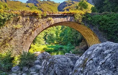 an old stone bridge over a river with rocks at Lovely Home In Vignale With Wifi in Vignale