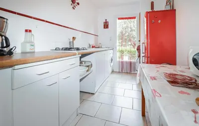 a kitchen with white cabinets and a red refrigerator at Lovely Home In Vignale With Wifi in Vignale