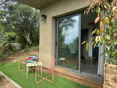 a patio with chairs and a table on the grass at Casaty Mare in Porto-Vecchio