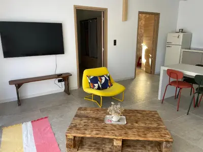 a living room with a yellow chair and a table at Casaty Mare in Porto-Vecchio